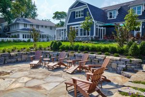 suburban,backyard,patio,with,adirondack,chairs,and,lush,garden